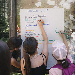 Kinder arbeiten während eines Workshops gemeinsam an einer Tafel © Maria Knoll